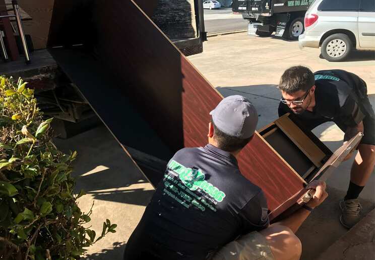 Junk Boss team hauling office furniture during a commercial junk removal job in Oklahoma City, Oklahoma.