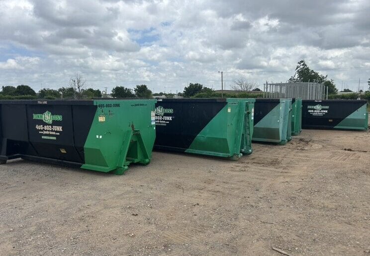 A lineup of Junk Boss roll-off dumpsters ready for delivery in Oklahoma City, Oklahoma.